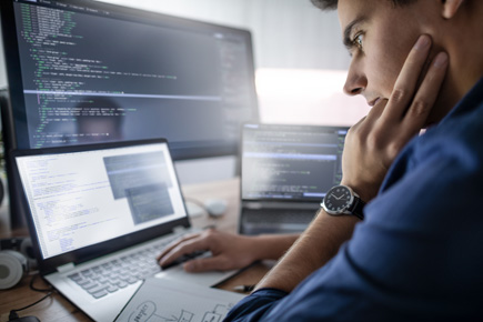 Man staring at code on a computer screen